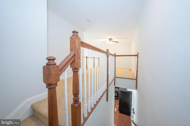 an empty room with ceiling fan and windows