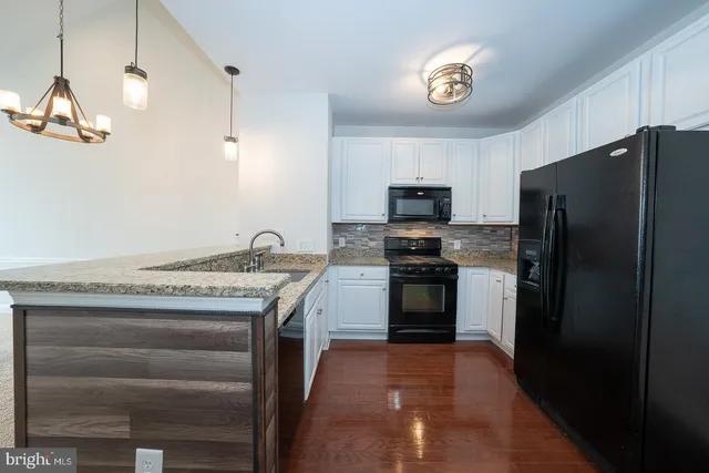 a kitchen with stainless steel appliances granite countertop a refrigerator a stove a sink and a refrigerator