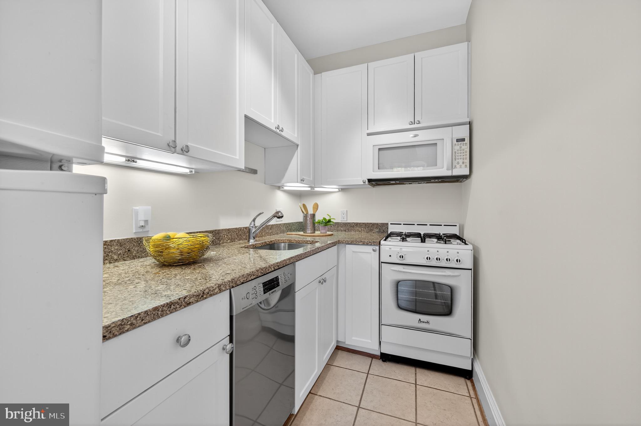 3446 Connecticut Avenue Northwest, Unit 305 Washington, DC 20008 - Photo 7 of 15 a kitchen with stainless steel appliances granite countertop a sink and a stove