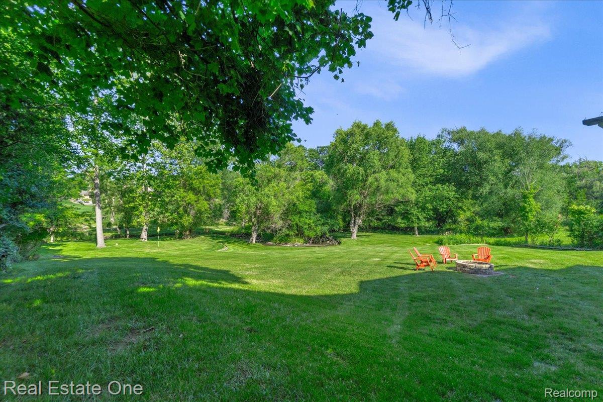 33850 Braebury Ridge Farmington, MI 48331 - Photo 71 of 85 Expansive green lawn with a built-in stone fire pit