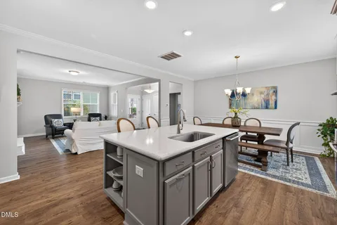 a large white kitchen with a large island in the center