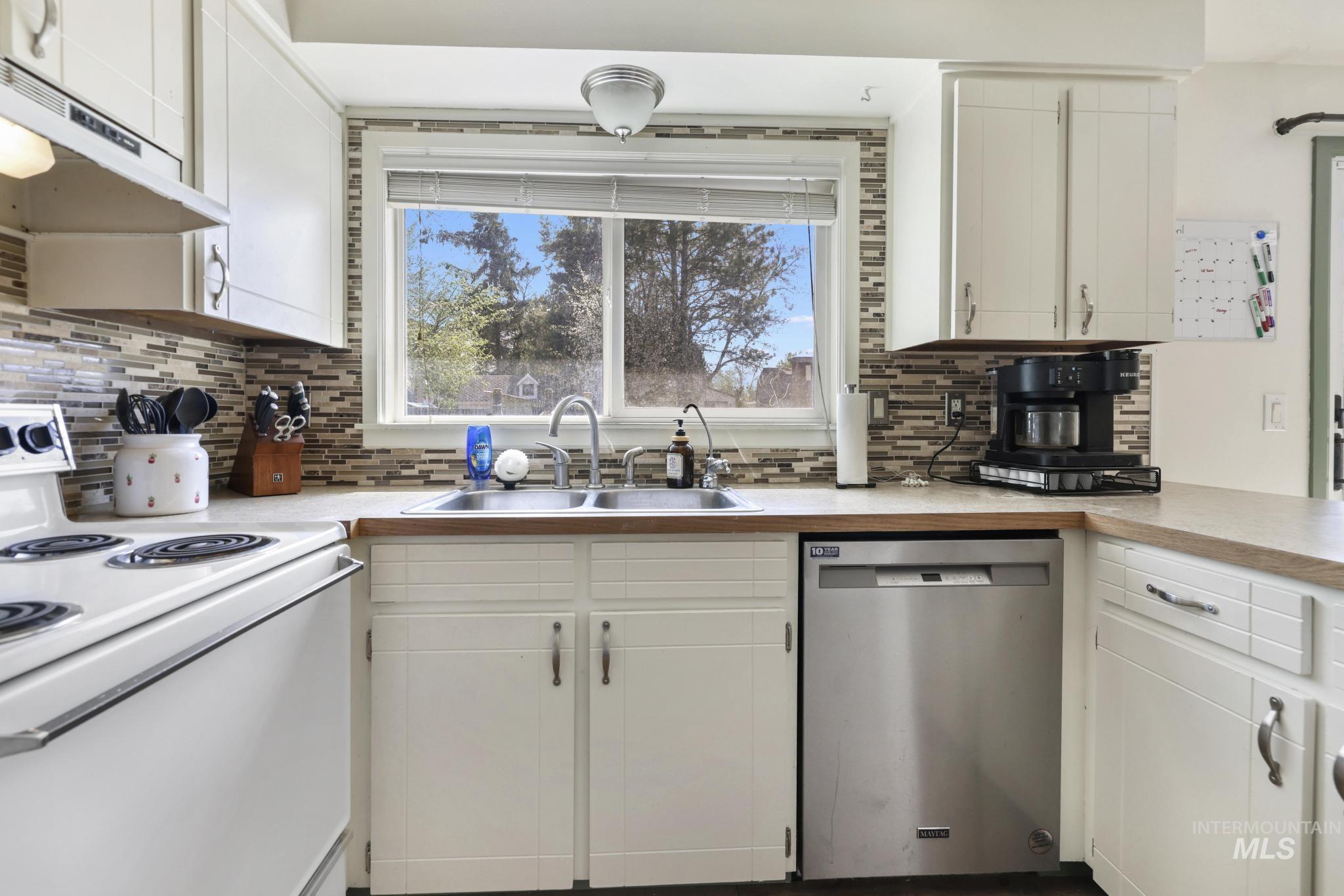 433 Ridgeway Drive Twin Falls, ID 83301 - Photo 8 of 18 Kitchen featuring electric range, dishwasher, white cabinetry, and light countertops