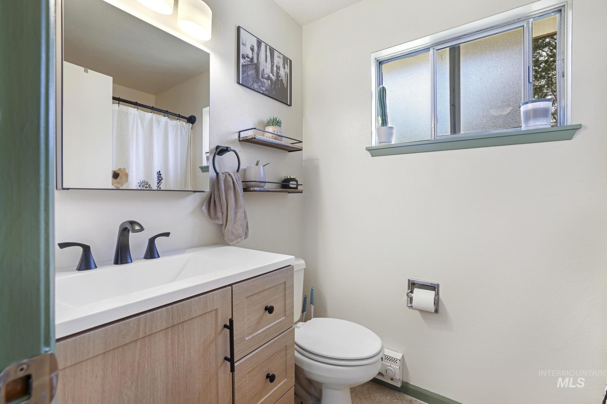 433 Ridgeway Drive Twin Falls, ID 83301 - Photo 10 of 18 Full bath featuring a shower with curtain, vanity, and baseboard heating