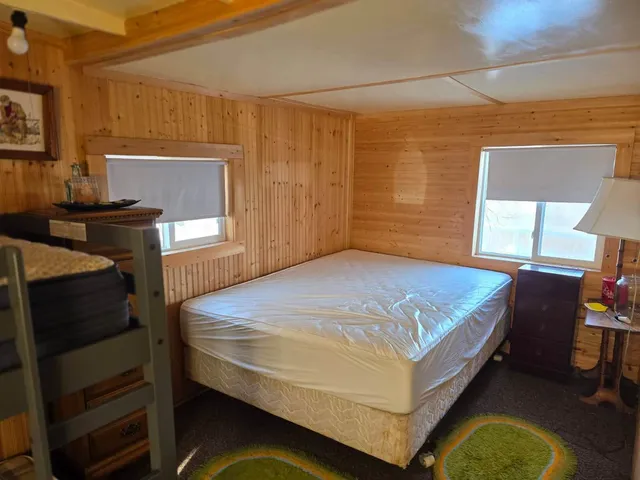 a bedroom with a bed and windows