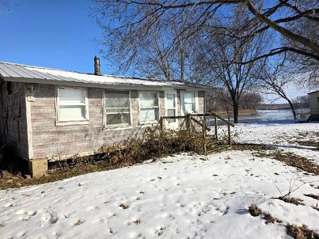 a front view of a house with a yard covered with snow