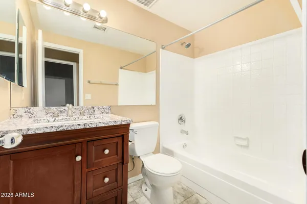 a bathroom with a granite countertop sink toilet mirror and shower