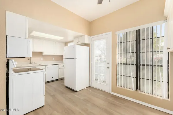 a kitchen with a refrigerator a sink and dishwasher with wooden floor
