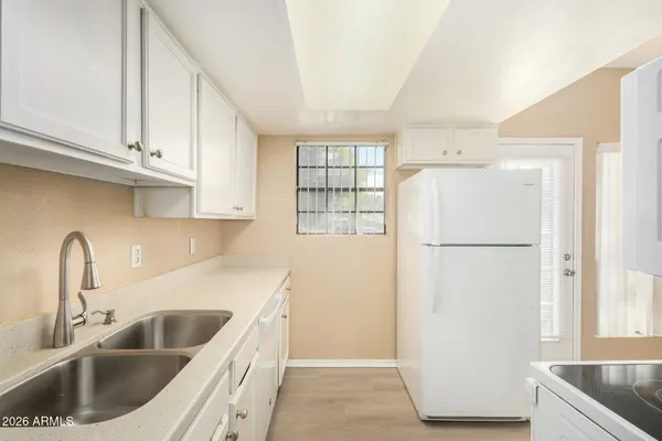 a kitchen with a refrigerator sink and cabinets