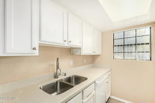 a kitchen with stainless steel appliances granite countertop a sink and a white cabinets