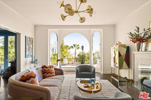 a living room with furniture a fireplace and a chandelier