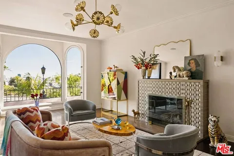 a living room with furniture a fireplace and a chandelier
