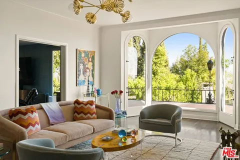 a living room with furniture large window and table