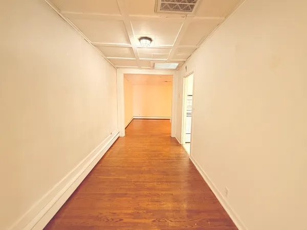 a view of a room with wooden floor and a window