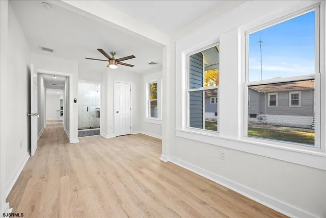 a view of empty room with wooden floor