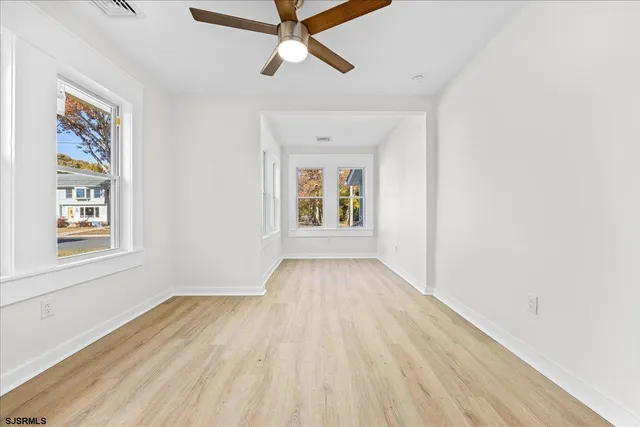 a view of an empty room with wooden floor
