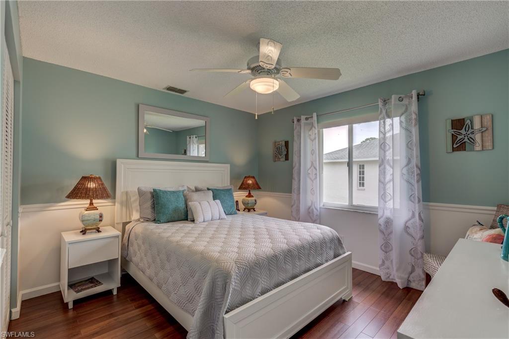 760 Augusta Boulevard, Unit D204 Naples, FL 34113 - Photo 10 of 32 a bedroom with a bed and a chandelier