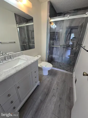 a bathroom with a granite countertop sink toilet and shower