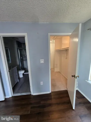a view of a hallway with wooden floor and closet