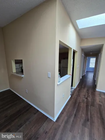 a view of a hallway with wooden floor and stairs