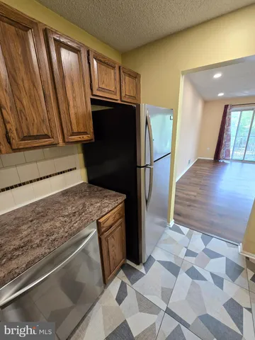 a kitchen with stainless steel appliances granite countertop a refrigerator and a stove