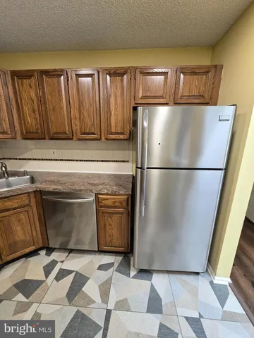 a view of a refrigerator in kitchen with stainless steel appliances wooden cabinets and glass door