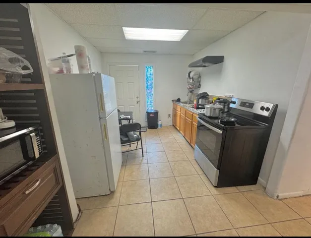 a kitchen with granite countertop a refrigerator and a stove