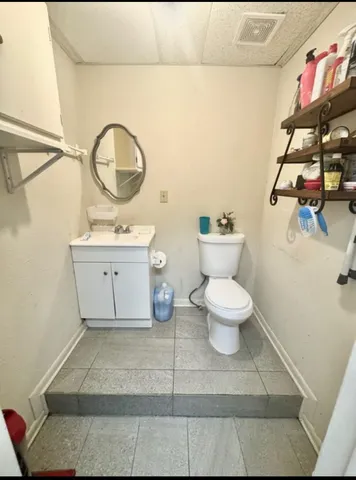 a bathroom with a toilet sink and mirror