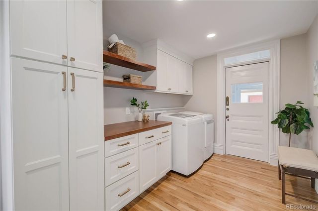 a kitchen with white cabinets and wooden floor