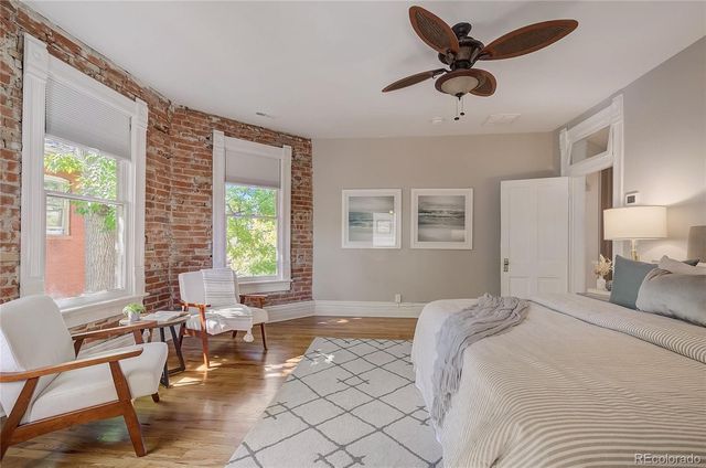 a bedroom with a bed a table and a large window
