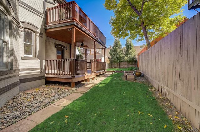 a view of a house with backyard and wooden fence