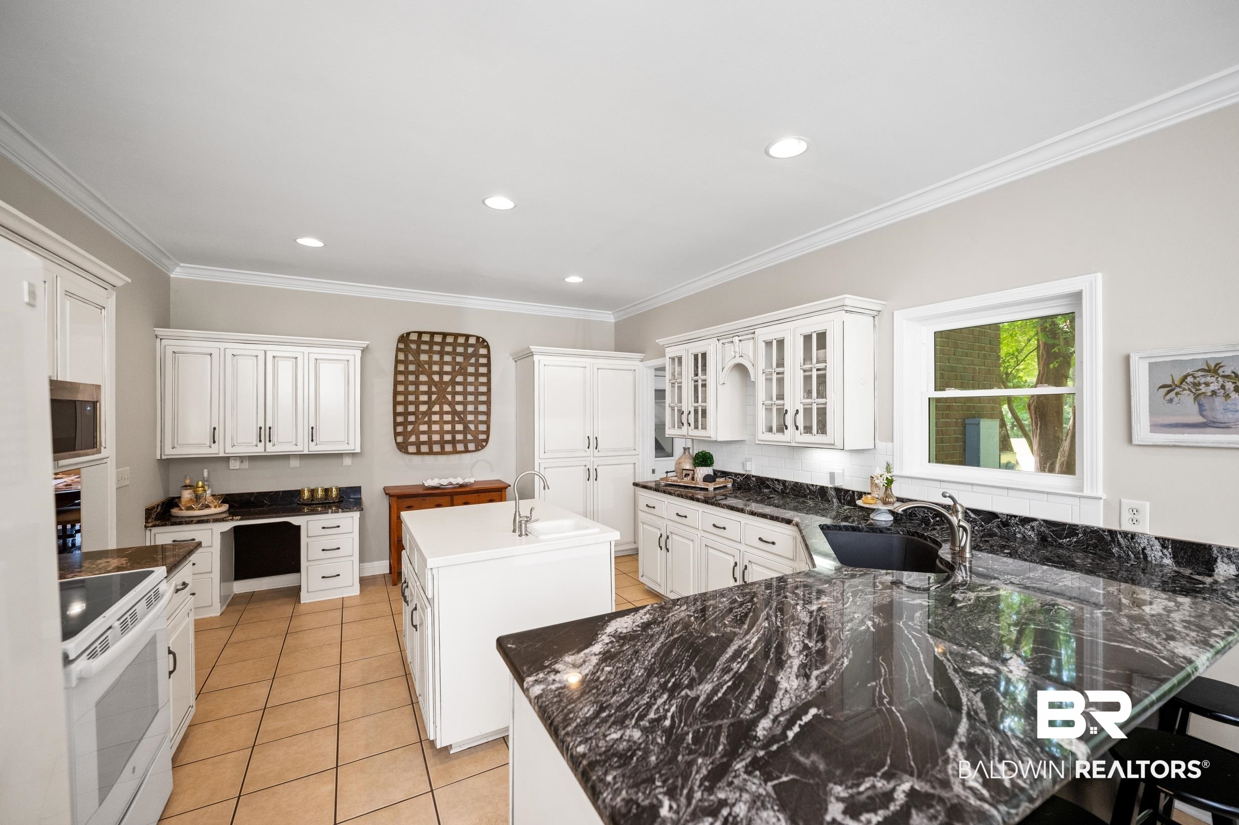 196 Morning Ridge Road Monroeville, AL 36460 - Photo 23 of 71 Kitchen featuring white electric range, stainless steel microwave, a center island with sink, crown molding, and a peninsula