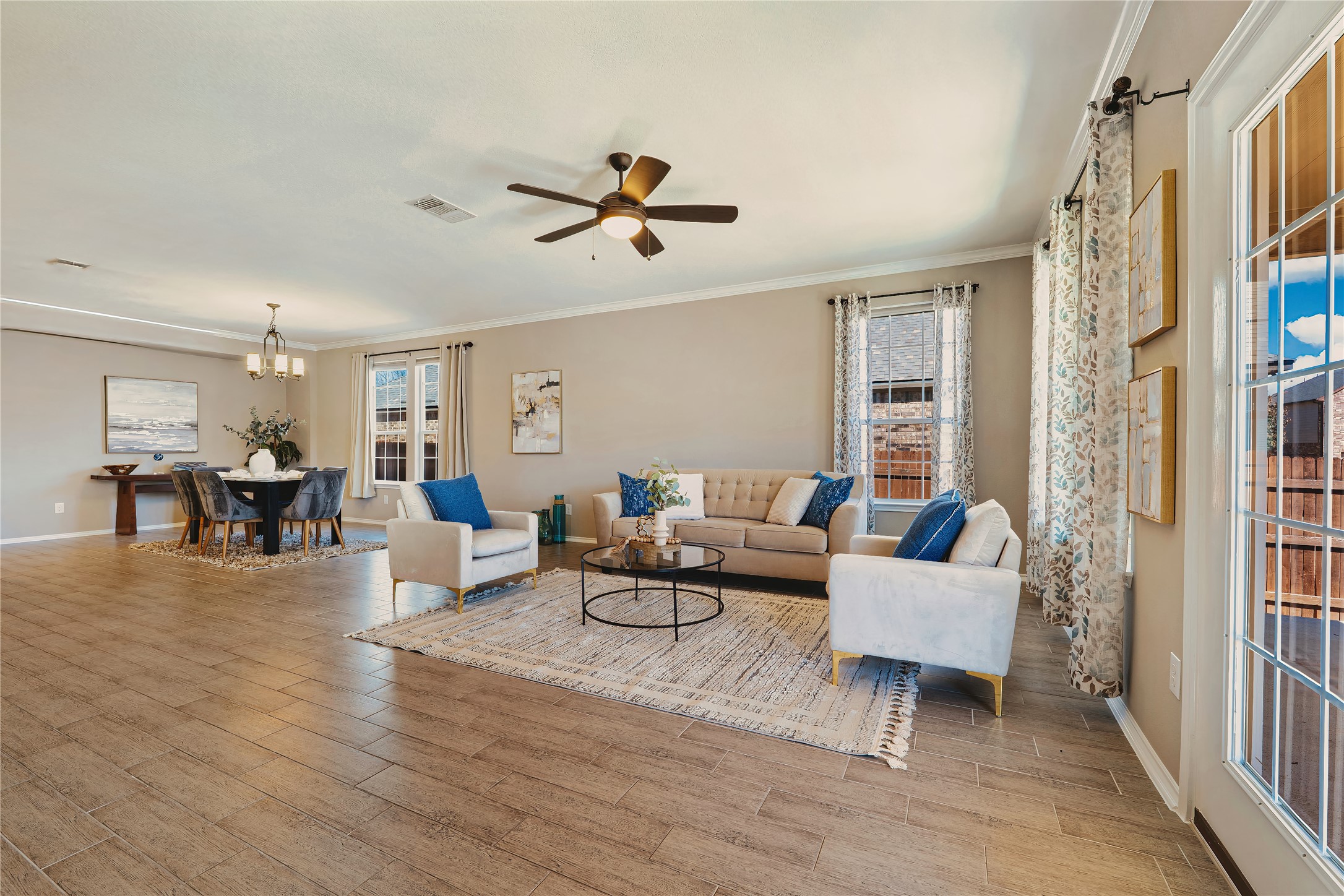 207 Telluride Drive Georgetown, TX 78626 - Photo 11 of 40 Living room with ceiling fan, crown molding, and light wood tile-style floors. Enjoy the French doors that lead you to the back patio