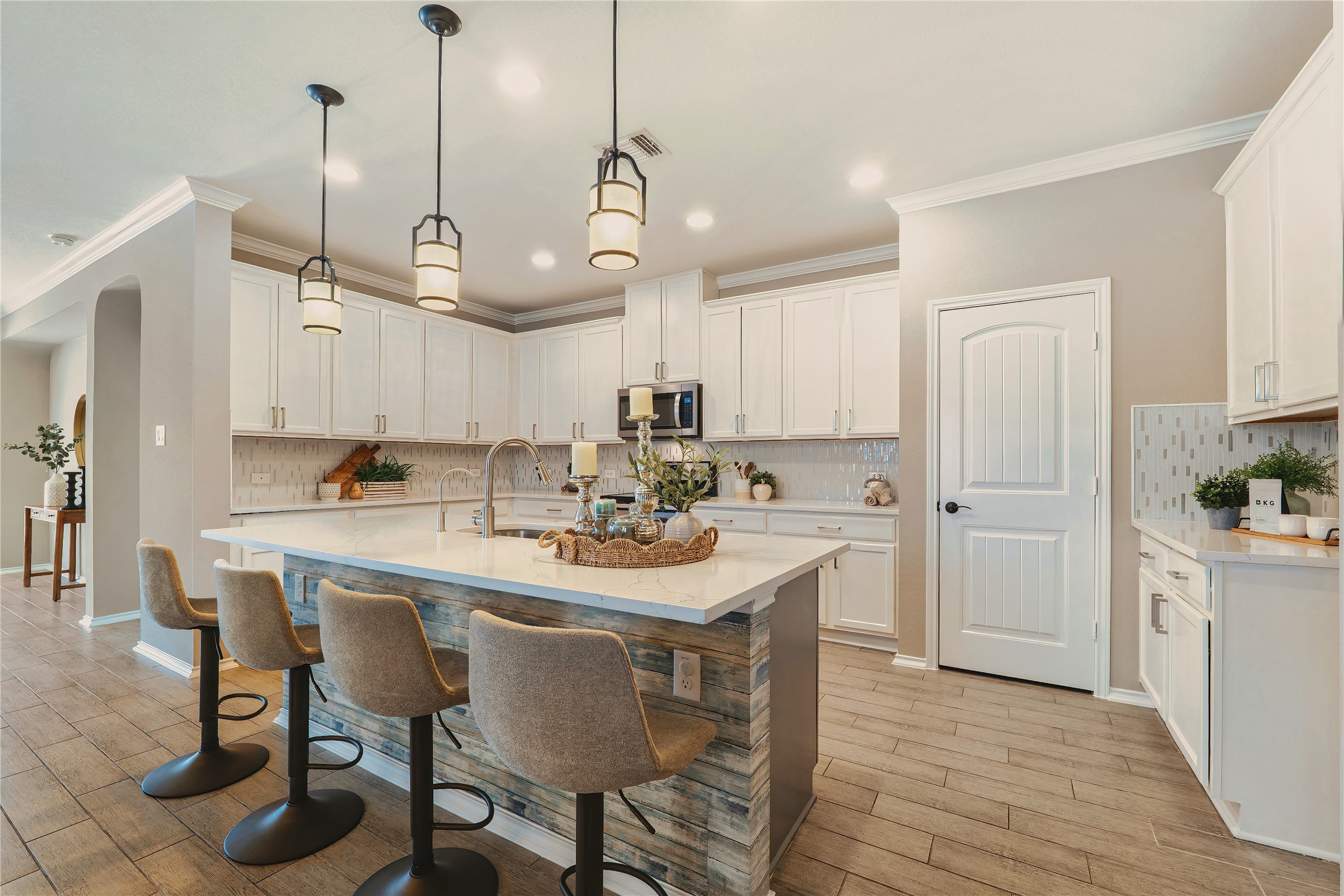 207 Telluride Drive Georgetown, TX 78626 - Photo 13 of 40 Kitchen with backsplash, a kitchen breakfast bar, decorative light fixtures, crown molding, white cabinetry and spacious pantry