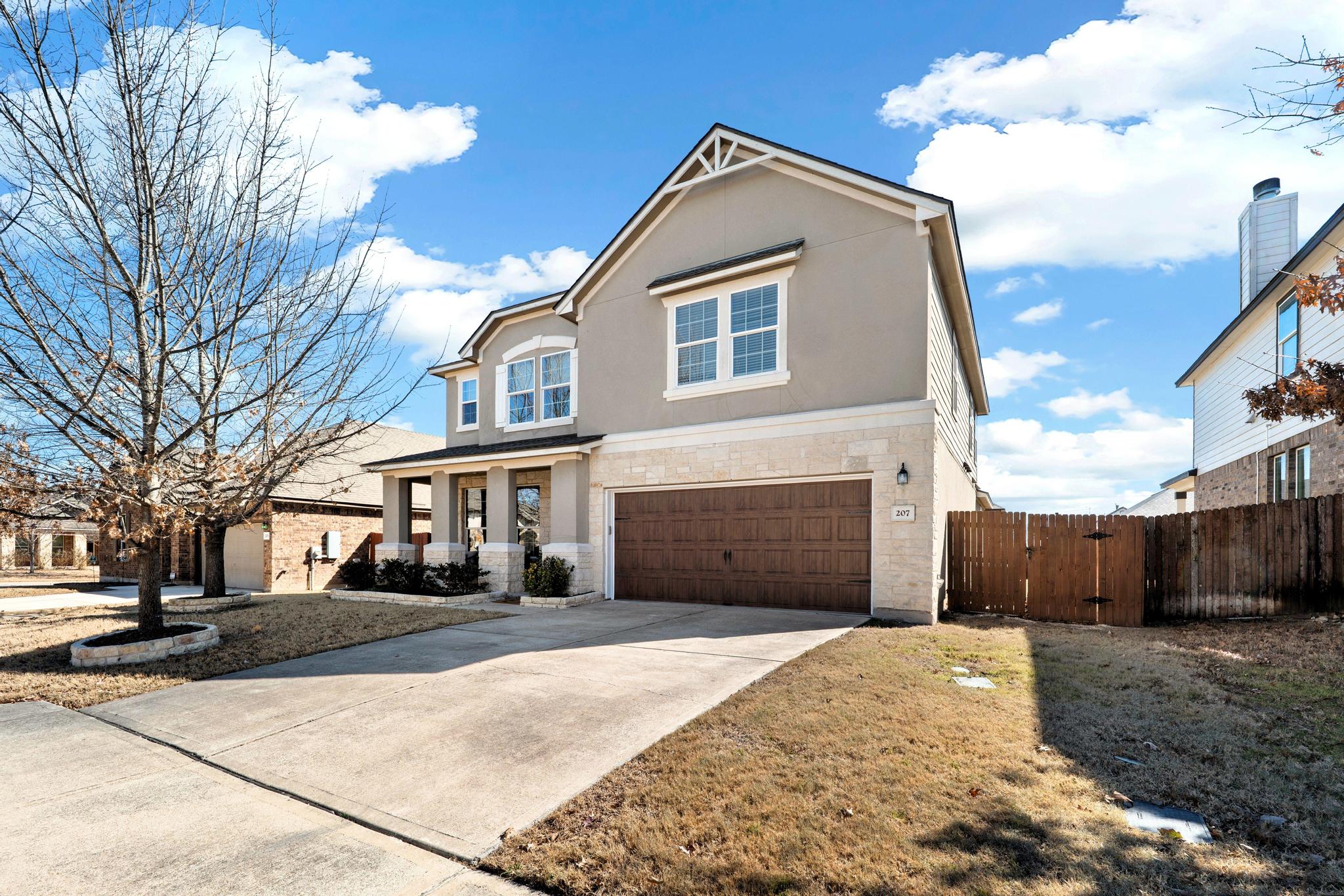 207 Telluride Drive Georgetown, TX 78626 - Photo 2 of 40 Current view of the front of this Traditional-style home with a gate, a garage, concrete driveway, stucco, Texas Stone, and siding. Enjoy the front covered porch