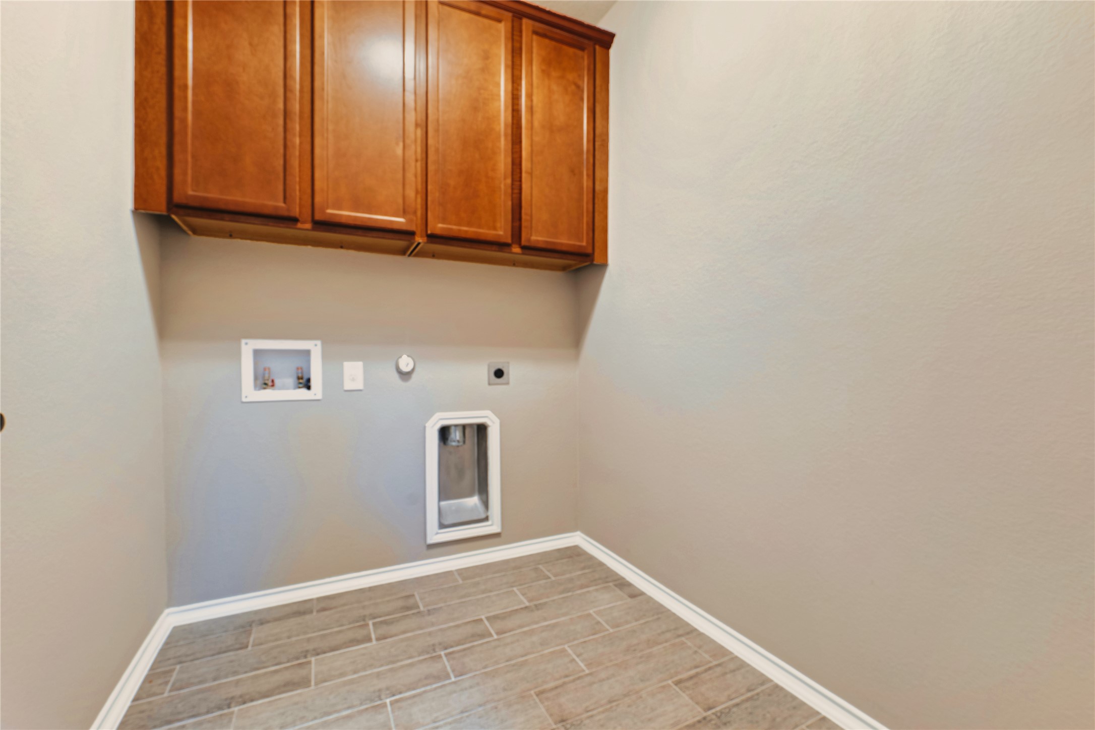 207 Telluride Drive Georgetown, TX 78626 - Photo 33 of 40 Laundry area with gas dryer hookup, wood tiled floors, washer hookup, cabinet space, and electric dryer hookup