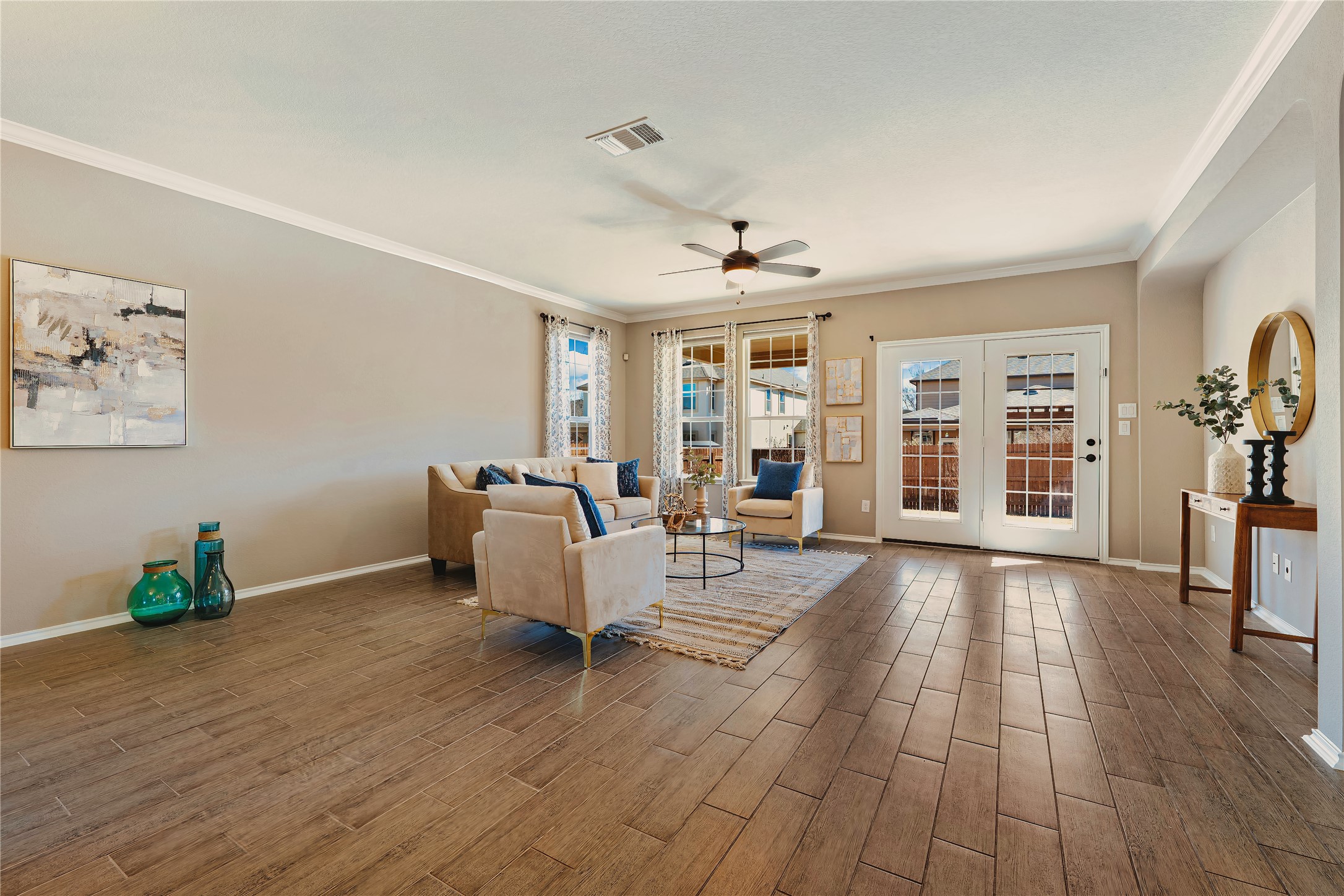 207 Telluride Drive Georgetown, TX 78626 - Photo 9 of 40 Living room with a ceiling fan, crown molding, and wood tiled floors.