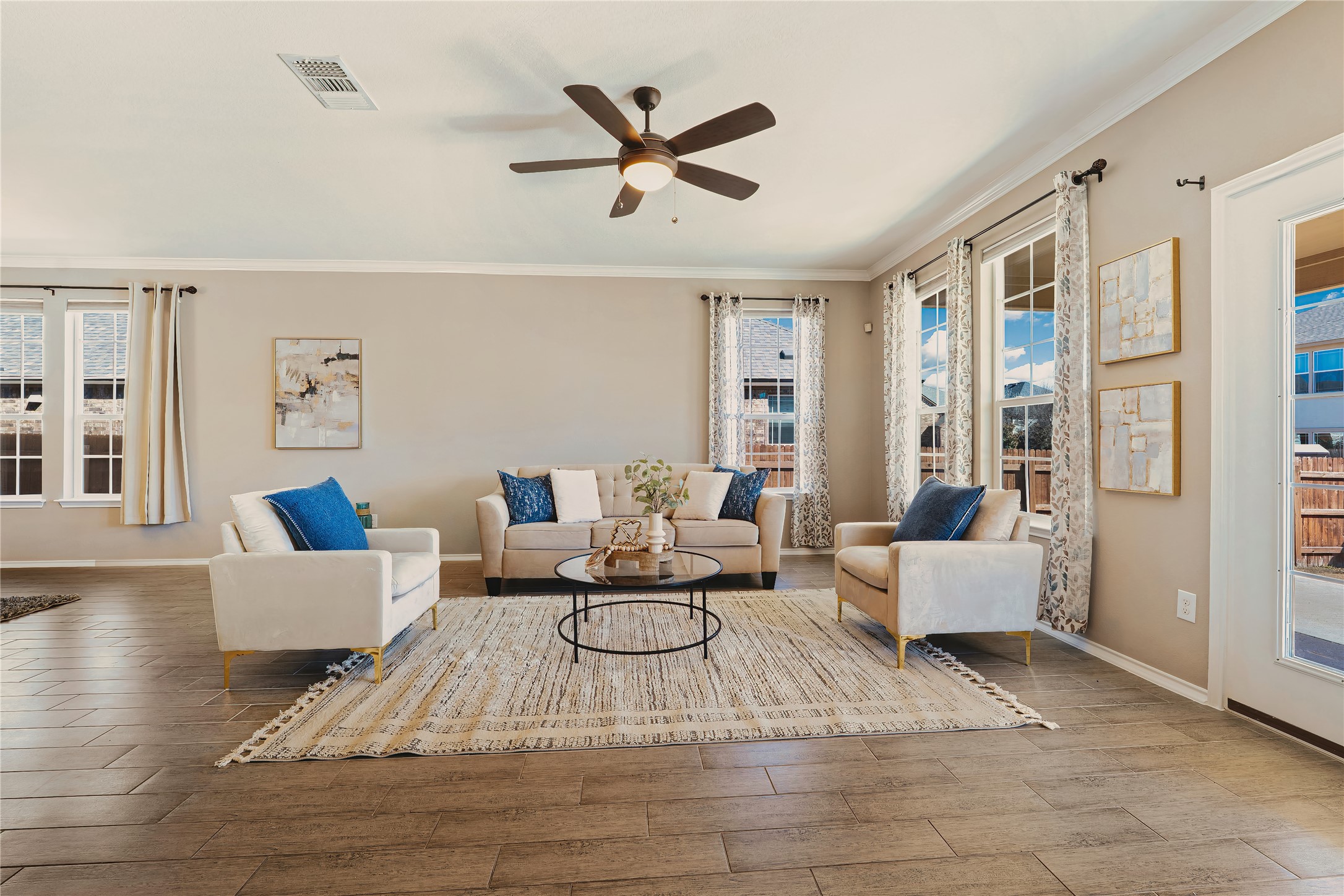 207 Telluride Drive Georgetown, TX 78626 - Photo 10 of 40 Living area with ceiling fan, wood- tile finished floors, tons of natural light, and crown molding