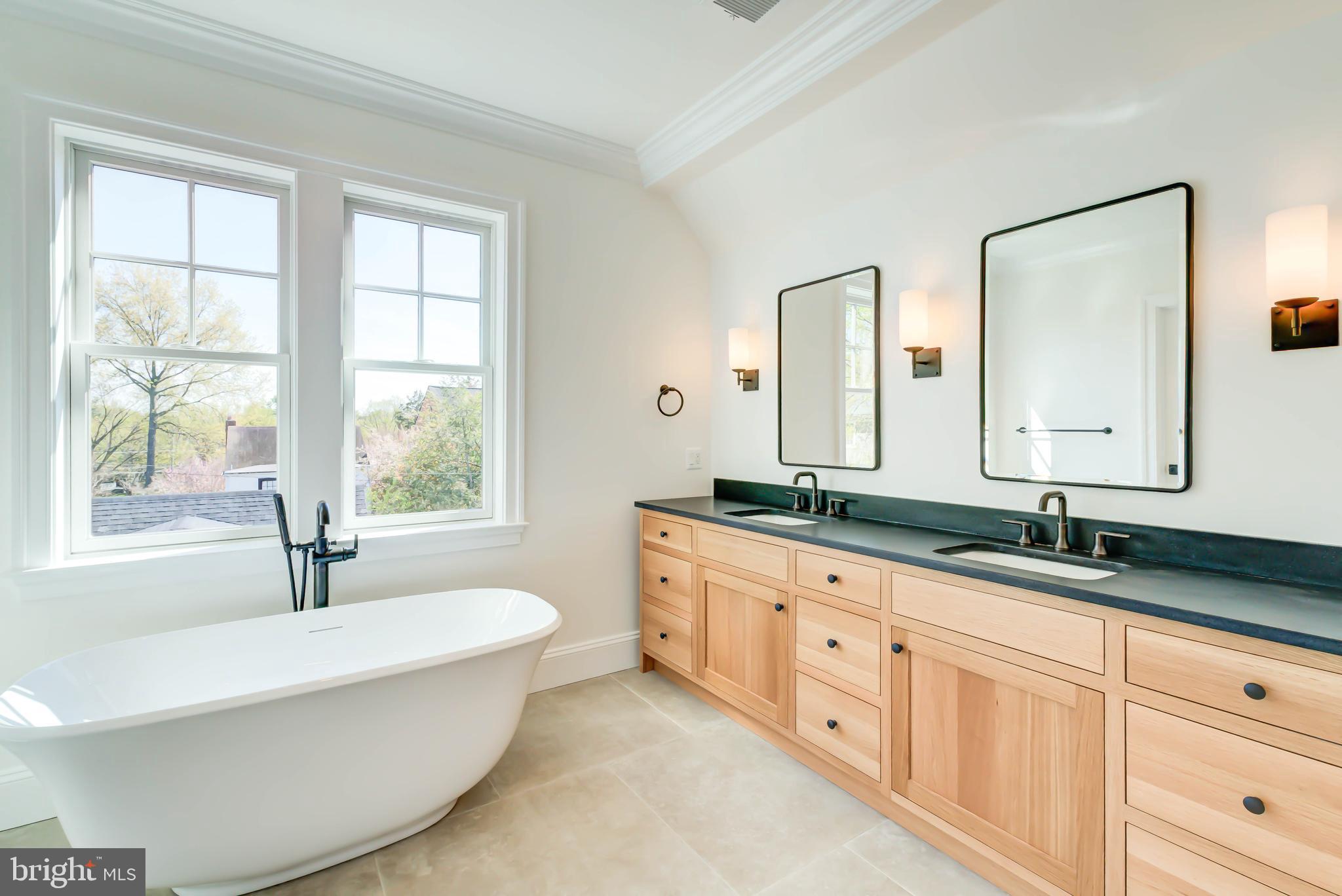 3118 Patterson Street Northwest Washington, DC 20015 - Photo 37 of 79 a bathroom with double vanity sinks a mirror and a bathtub next to a window