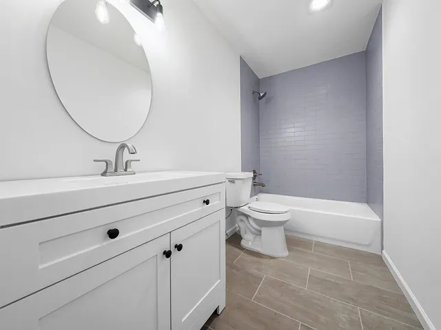 a bathroom with a sink a toilet and a mirror