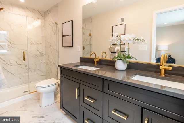 a bathroom with a granite countertop sink a toilet and a mirror