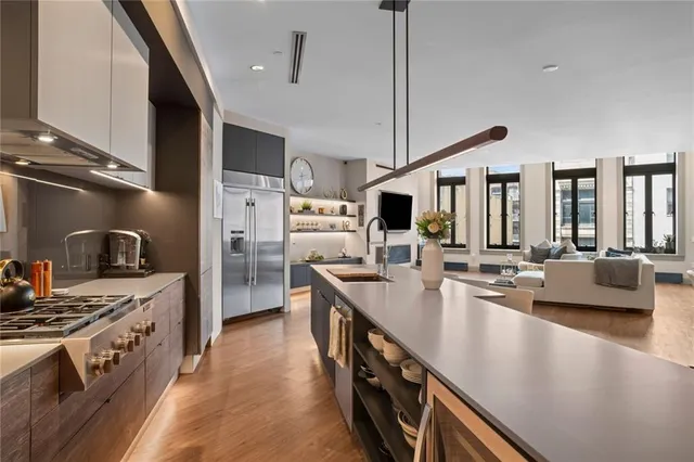 a large kitchen with stainless steel appliances a sink a stove and cabinets