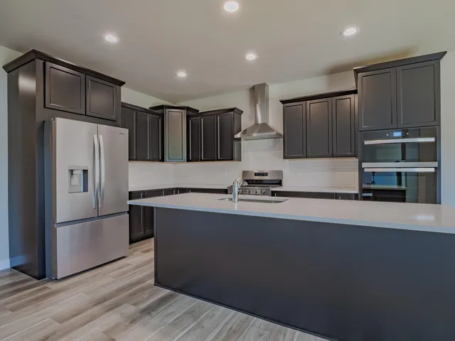 a kitchen with granite countertop a refrigerator and a sink