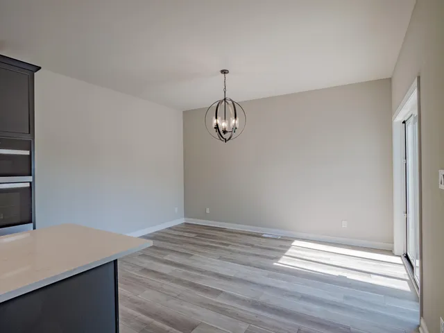 a view of a room with wooden floor and white walls