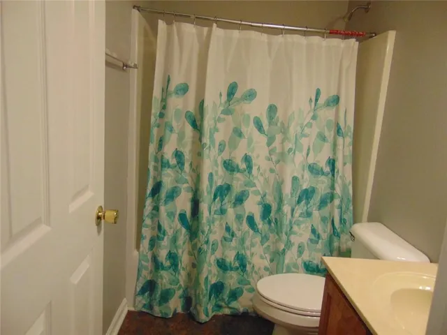 a white toilet sitting next to a shower curtain