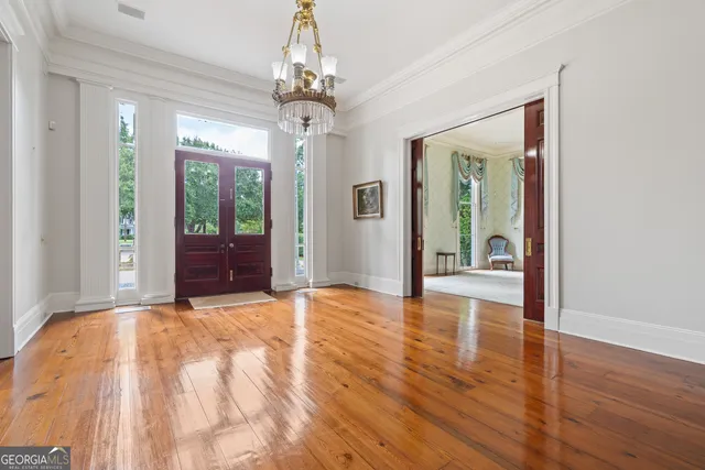 a view of a hallway with wooden floor and staircase