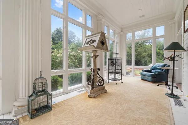 a view of a porch with wooden floor and fence and a floor to ceiling window