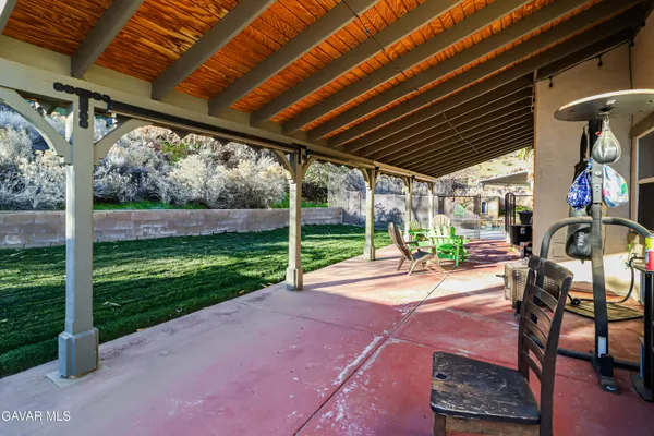 a view of a backyard with table and chairs potted plants with wooden fence