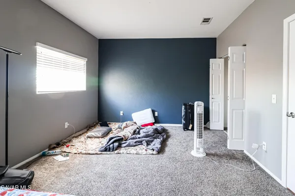 a bedroom with bed and a mirror