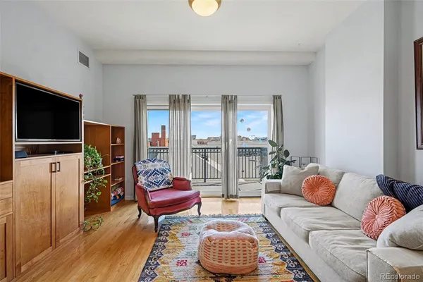 a living room with furniture a flat screen tv and a large window