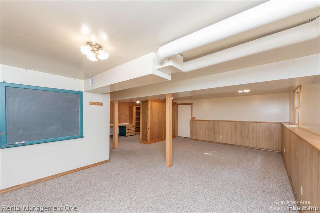 7870 Chamberlin Road Dexter, MI 48130 - Photo 35 of 52 Carpeted floor, wood paneling, recessed lighting, ceiling-mounted light fixture, built-in desk with shelving